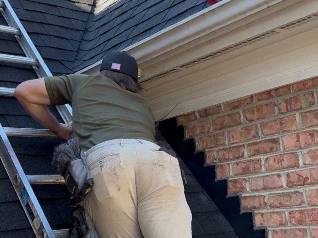 Integrated Wildlife Management technician safely removing nuisance wildlife from a home's roofline in Mebane, NC using humane exclusion methods.